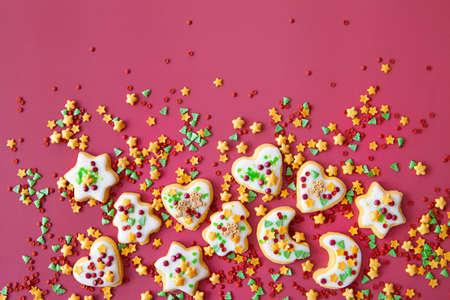 Colorful Christmas cookies with sugar sprinkles on a red backgroundの写真素材