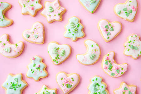 Colorful Christmas cookies with sugar sprinkles on a pink backgroundの写真素材