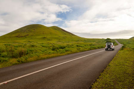 A car through a road in the middle of the countryside of Easter Island, Chileの写真素材
