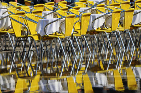 Yellow chairs from a restaurant being reflected on the water pools due to accua alta at Piazza San Marcos, Venice, Italyの写真素材