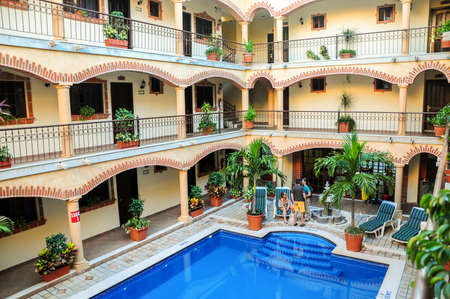 Interior of a hotel at Playa del Carmen in Quinata Roo province. The interiors shows lots of plants and a nice blue pool, with the balconies of the rooms looking towards the pool.のeditorial素材