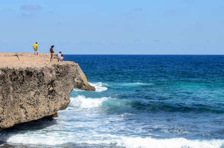 Group of tourists staring at the sea and taking some pictures near Boca Prins at Arubaの写真素材