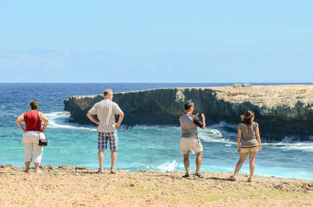 Group of tourists staring at the sea and taking some pictures near Boca Prins at Arubaのeditorial素材