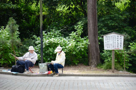 A man and a woman draw and paint the landscape around the Engakuji Temple in Kamakura prefecture, Japanのeditorial素材