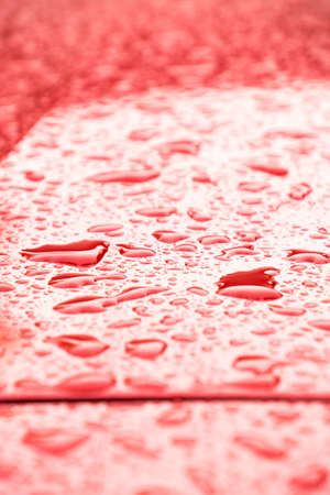 Small rain drops over a red car.Juan Lacaze, Colonia, Uruguayの写真素材