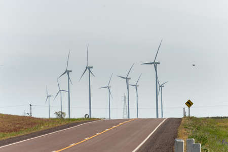 Solitaire route with a bunch of windmills on the background under a cloudy sky at Treinta y Tres,...