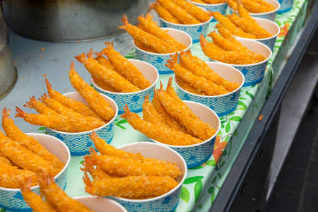 Small portions of panko-breaded fish ready to eat at a street stall in the Meyeon-dong market in...