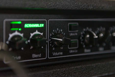 Details of a bass amp with knobs for volume, mix and other buttons to improve sound quality. The appliance has green lightsの写真素材