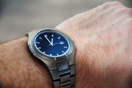 Man holds an antique gray watch and needles on his wristの写真素材