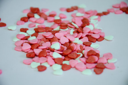 Small white, pink and red heart-shaped sweets to decorate a birthday cake