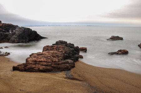 Long exposure of the sea hitting some rocks in Mansa beach, Punta del Esteの写真素材