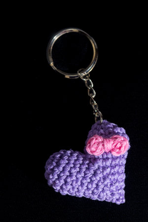crocheted purple heart-shaped keyrings on a black background