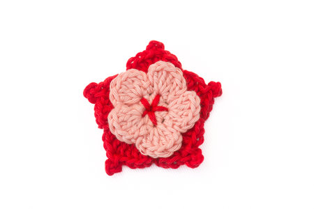 Colorful flower knitted with crochet, as hair clips, on a white background, isolatedの写真素材