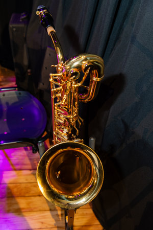 A gold colored saxophone is on display. The instrument is shiny and has a black and purple backgroundの写真素材