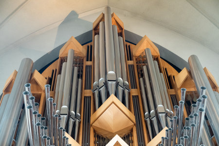 Large organ with many keys is shown Reikiavik cathedral. The organ is made of wood and has a very old-fashioned look to it. The image gives off a sense of nostalgia and reverence for the instrumentの写真素材