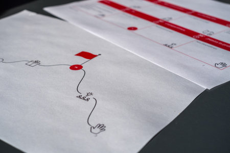 Printed documents with black and red illustrations on dark surfaceの写真素材