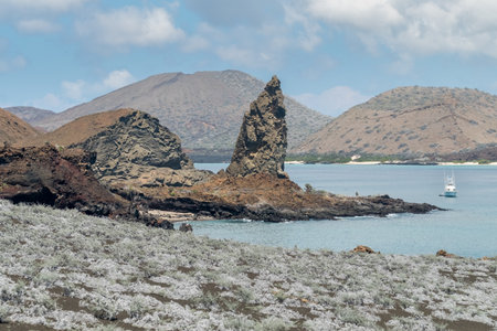 Rocky shoreline, sailboat, partly cloudy sky, arid mountain landscapeの写真素材
