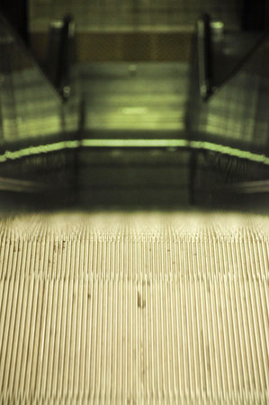 Close-up of escalator in motion with metallic steps and blurred background