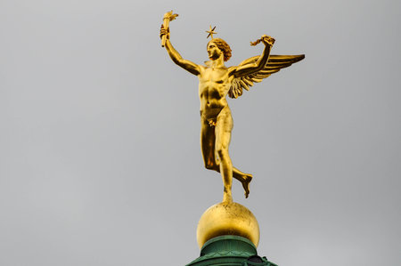 Paris, Ille de France, France. September 16, 2024: Golden statue of Mercury on top of a building in Paris, France.の写真素材