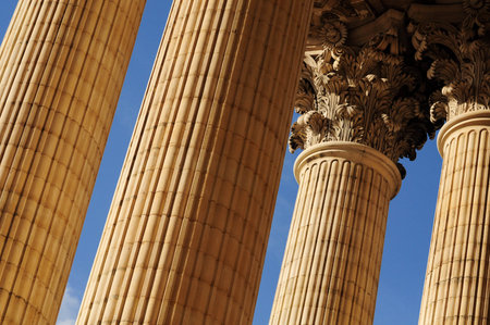 Close-up of majestic neoclassical columns against a clear blue sky