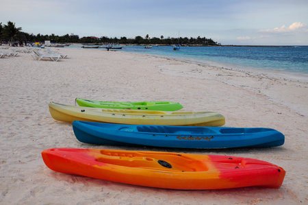 Colorful kayaks on tranquil beach inviting adventure on calm seaの写真素材
