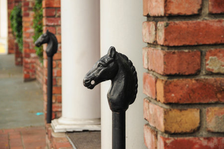 Vintage iron horse head posts line walkway by historic brick buildingの写真素材