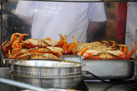 Steamed crabs stacked in tray at busy seafood market ready for servingの写真素材