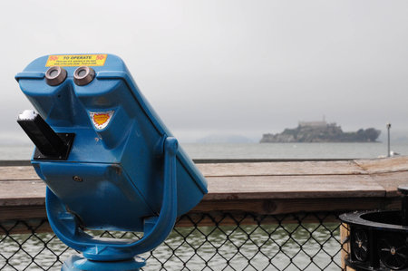 Blue telescope viewing Alcatraz prison on foggy San Francisco dayの写真素材