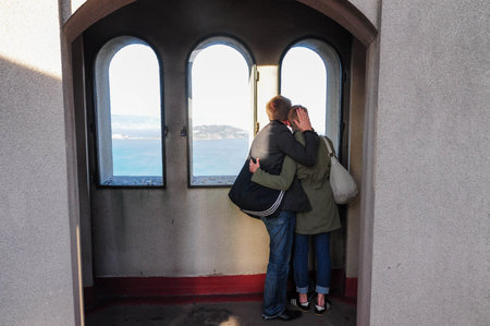 Couple Embracing with Scenic Bay View from Historic Towerの写真素材