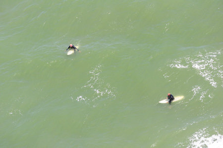 Surfers Waiting in Green Ocean Seen from Aboveの写真素材