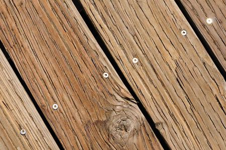 Weathered wooden planks with grain and screws in sunlightの写真素材