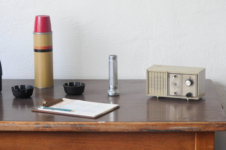 San Francisco, CA, USA. April 24, 2012: Vintage office setup with thermos, radio, and clipboard on a wooden desk.の写真素材