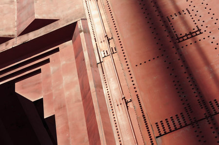 Rusty red industrial structure with geometric patterns and shadowsの写真素材