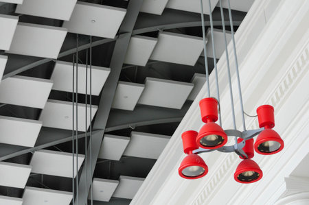 Modern ceiling with geometric patterns and vibrant red lighting contrastの写真素材