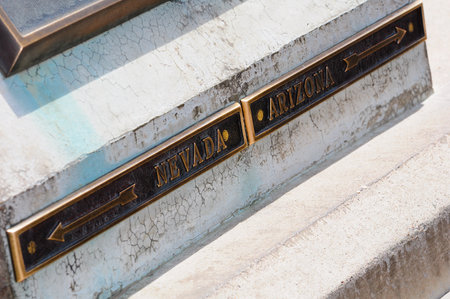 A bronze plaque marks the border between Nevada and Arizona on the historic Hoover Dam, showcasing its architectural significance.の写真素材