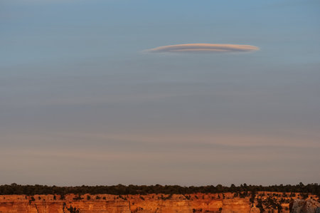 Grand Canyon sunset with a solitary cloud in a serene sky.の写真素材