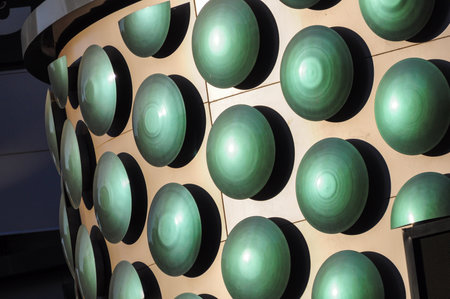 Green spherical architecture elements casting shadows on building facadeの写真素材