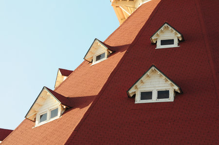 Red-roofed gables against clear sky, classic architecture meets coastal vibesの写真素材