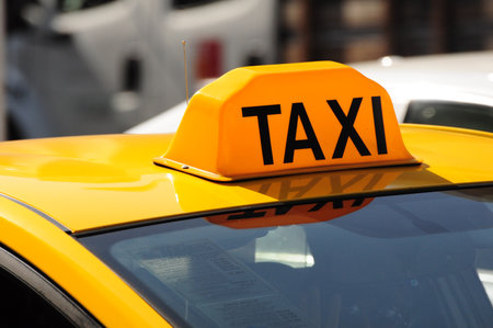 Yellow taxi roof sign close-up in city, highlighting urban transit and lifeの写真素材