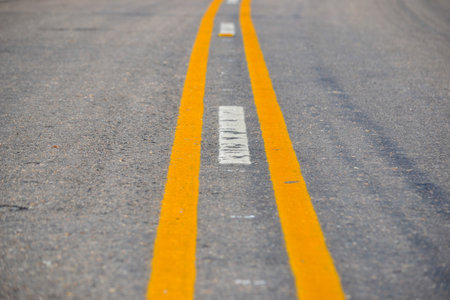 Empty rural road with yellow lines under clear sky in Uruguay.の写真素材