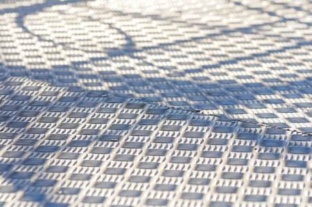 Geometric pattern on textured metal surface with light and shadow interplayの写真素材