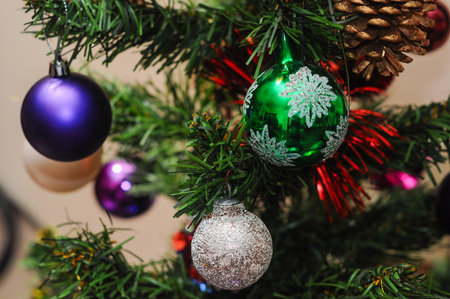 Festive Christmas tree with colorful ornaments and shimmering pine coneの写真素材