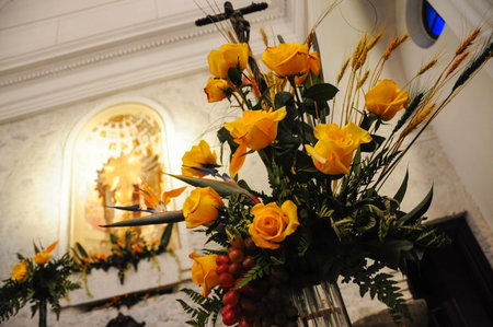 Yellow roses and wheat in historic building with religious art.の写真素材