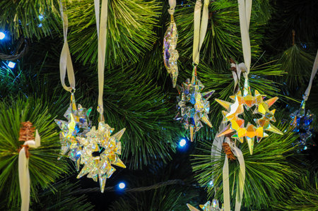 Star-shaped ornaments on lush Christmas tree create festive holiday atmosphereの写真素材