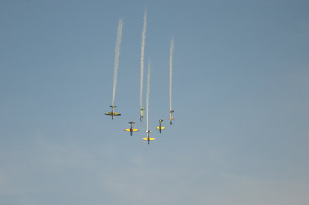 Aerobatic aircraft in synchronized descent against clear blue sky.の写真素材