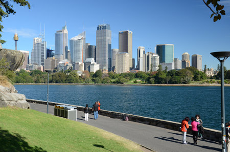 Sydney, New Sowth Wales, Australia. May 19, 2013: People enjoy a sunny day along the waterfront with the Sydney skyline in the background.の写真素材