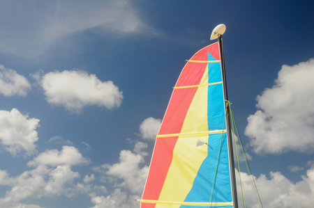 Sail with vibrant blue sky and fluffy white clouds