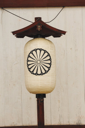 Japanese paper lantern on wooden post against rustic wallの写真素材