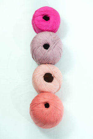 Colorful Yarn Balls in Pink and Peach Tones on Light Backgroundの写真素材