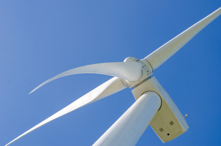 Wind turbine close-up against clear sky, highlighting renewable energy